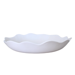 Shallow Wavy Serving Bowl made of white ceramic with a distinctive undulating rim and graceful curves.
