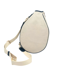 The Tutu Tennis Sling off-white canvas teardrop sling bag with navy trim, gold hardware, studio shot.