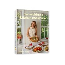 The Wishbone Kitchen Cookbook, white hardcover rectangular book with a cover photo of Meredith Hayden holding a savory galette, perfect for entertaini