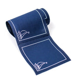 Sail Away Cocktail Napkins in navy blue paper with white sailboat outline pattern and border, partially unrolled on a white background.