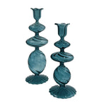 Blue Swirl Candlestick: pair of blue glass candlesticks with stacked bulbous shapes, dark swirls, and a ribbed base on white.