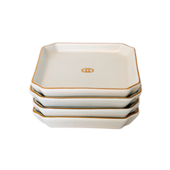 Vintage Gucci Gold Gilt Coasters | Set of 4, square white ceramic with gilded edges and GG logo, stacked.