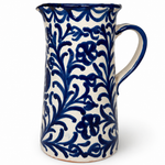 Pomegranate Straight Pitcher, a cream ceramic pitcher with a cobalt blue floral vine pattern and sturdy handle.