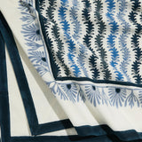 Leyla Lapis Mahjong Tablecloth, white fabric with vertical lapis blue leaf pattern and light blue floral border, draped.