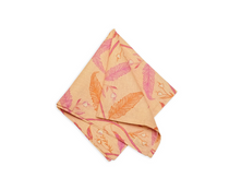 Tuileries Napkin | Set of 4 in peach linen with vibrant pink & orange botanical pattern, neatly folded.