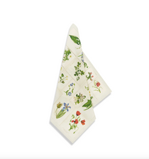 Botanical Tiles Linen Napkin, cream linen, folded diagonally to display a vibrant grid of multicolor botanical illustrations, studio shot.