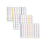 Elisabeth Coated Placemat. Three rectangular white placemats with a vibrant multi-colored grid pattern, stacked diagonally.