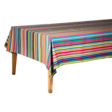 Salvador Coated Tablecloth, a rectangular multicolor striped coated fabric draped on a light brown wooden table.