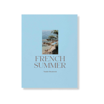 French Summer by Natalie Obradovich, a sky blue hardcover book featuring a centered Mediterranean coastal photo and elegant gold title.
