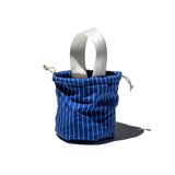 Shirt Fabric Drawstring Bag, bright blue with white vertical stripes, white webbing handle, natural rope drawstring, standing upright.