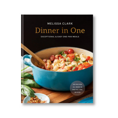 Dinner in One cookbook with black cover featuring pasta dish in blue enameled pan with wooden spoon