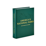 America's National Parks" Book, dark green leather with embossed mountain range and gold foil text, standing on a white surface.