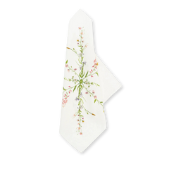 Our June Floral Linen Napkin, white linen with a delicate wildflower pattern in pink, purple, and green, elegantly folded.