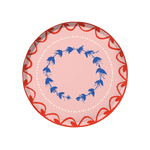 Fête Dinner Plate | Set of 12, round paper plate with pink base, red scalloped border, blue floral wreath, and white dots.