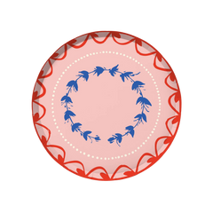 Fête Dinner Plate | Set of 12, round paper plate with pink base, red scalloped border, blue floral wreath, and white dots.