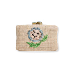 The Zinnia Clutch: rectangular woven raffia clutch with blue & pink embroidered zinnia, green leaves, brass clasp, on white.